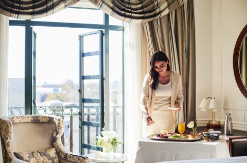 A woman enjoying breakfast in her suite at The Charleston Place